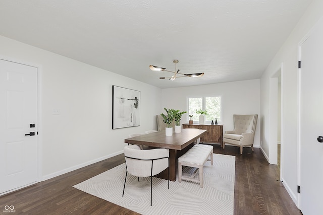 dining room featuring an inviting chandelier, dark wood finished floors, and baseboards