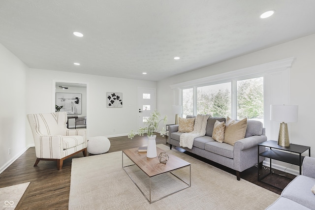 living area featuring recessed lighting, baseboards, and dark wood finished floors
