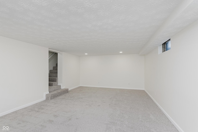 finished basement with carpet floors, a textured ceiling, recessed lighting, baseboards, and stairway