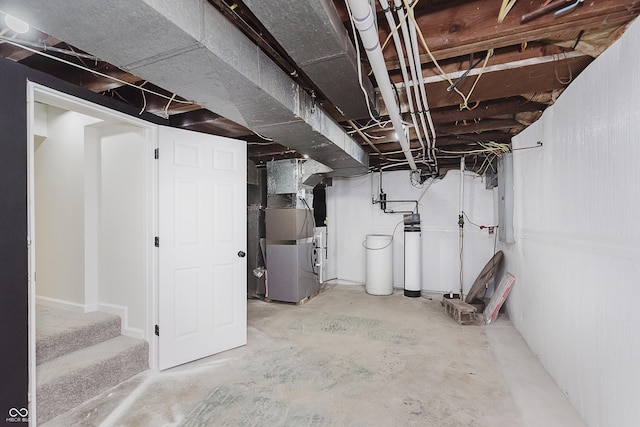 unfinished below grade area featuring stairs, washer / clothes dryer, and heating unit