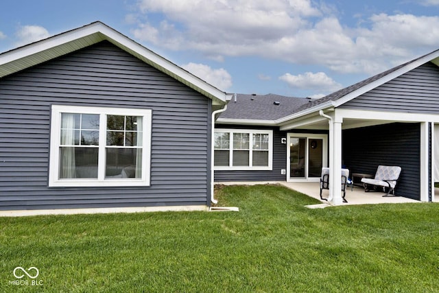 rear view of house with a yard and a patio