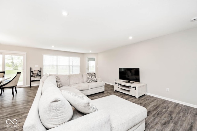 living room featuring dark wood-type flooring, recessed lighting, and baseboards