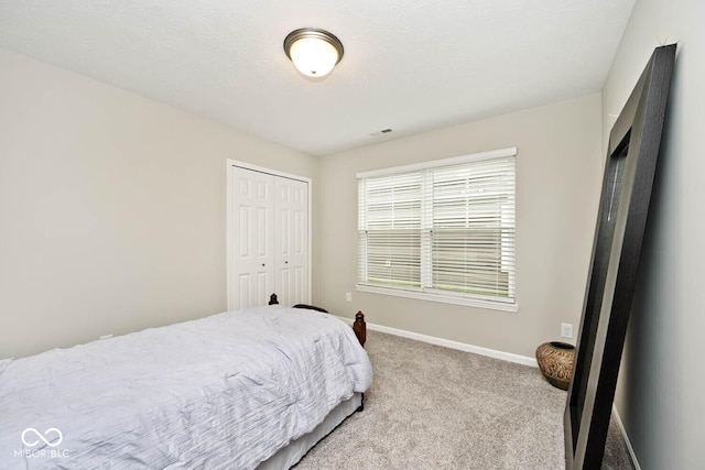 bedroom featuring baseboards, carpet, visible vents, and a closet