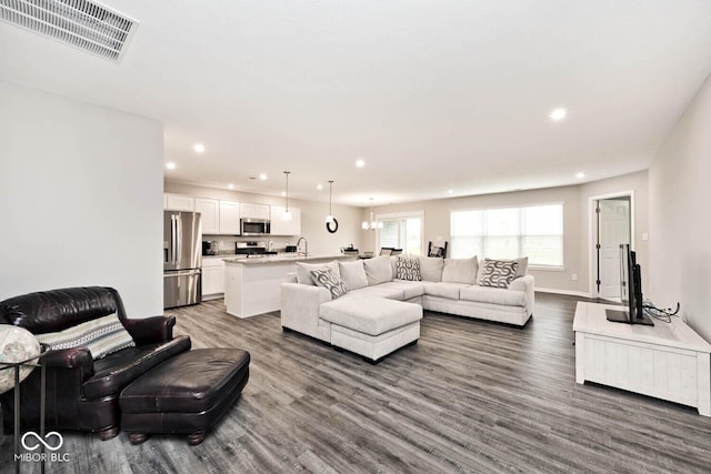 living room featuring visible vents, an inviting chandelier, dark wood-style flooring, baseboards, and recessed lighting