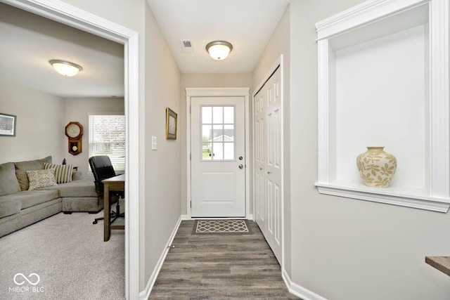 doorway to outside with baseboards, dark wood-style floors, and visible vents