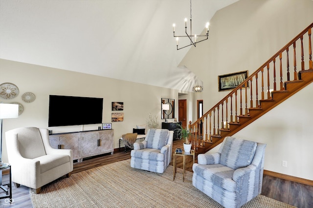 living room with an inviting chandelier, wood finished floors, high vaulted ceiling, baseboards, and stairs