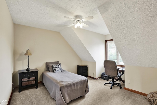 carpeted bedroom with vaulted ceiling, a textured ceiling, baseboards, and a ceiling fan