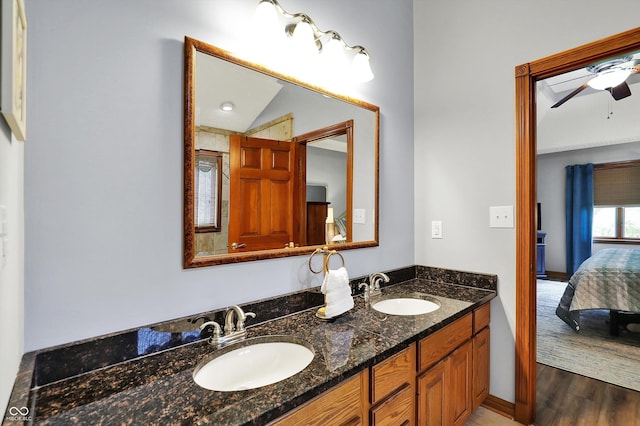 ensuite bathroom with a sink, connected bathroom, a ceiling fan, and wood finished floors