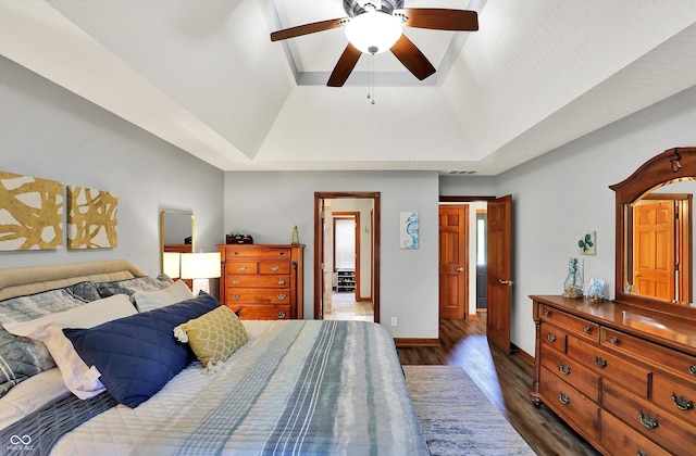 bedroom featuring a ceiling fan, baseboards, dark wood-style flooring, and a raised ceiling