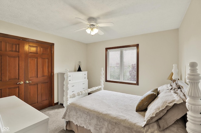 bedroom with light carpet, a textured ceiling, and a ceiling fan