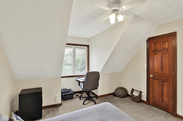 bedroom featuring lofted ceiling, carpet, a textured ceiling, baseboards, and ceiling fan