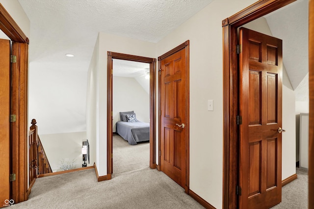 corridor featuring baseboards, an upstairs landing, and carpet