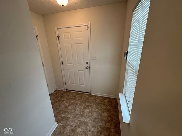 entryway featuring baseboards and a textured ceiling