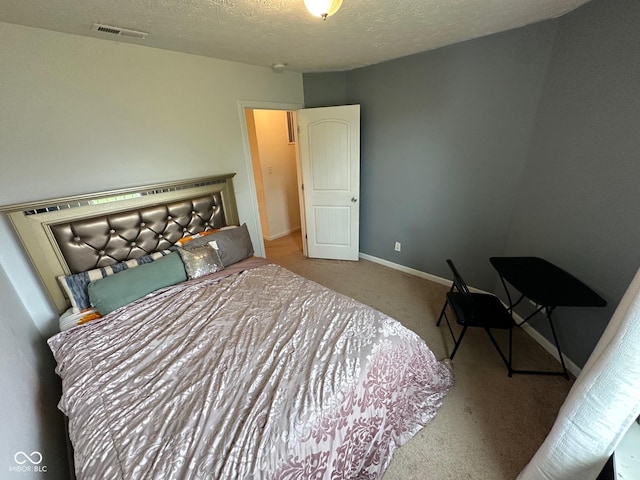 carpeted bedroom featuring visible vents, a textured ceiling, and baseboards