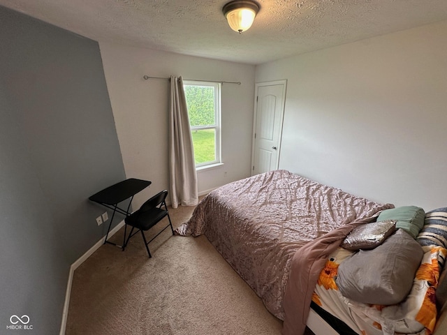 bedroom with a textured ceiling and light colored carpet