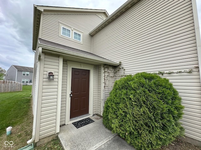 property entrance featuring a yard and fence