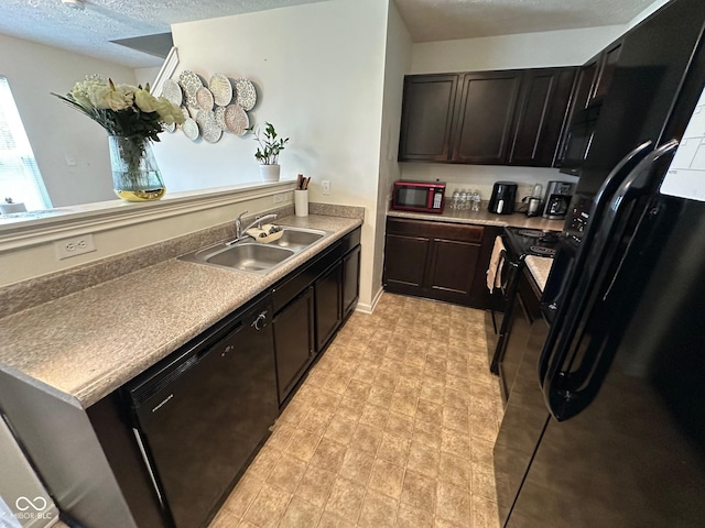 kitchen featuring a sink, black appliances, a peninsula, and a textured ceiling