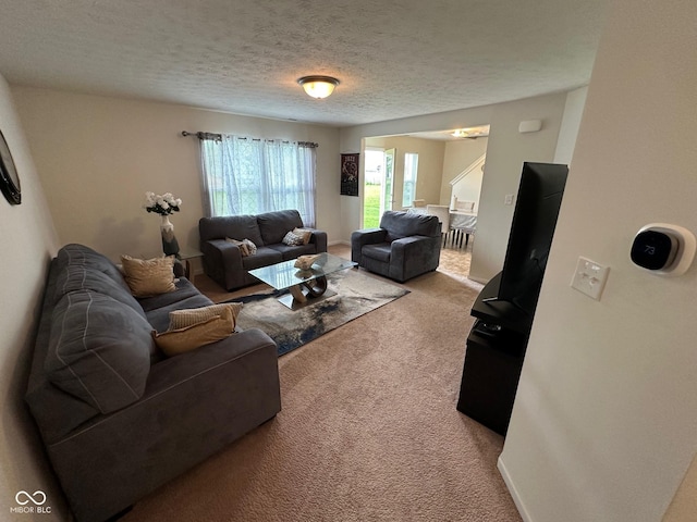 carpeted living room featuring a textured ceiling