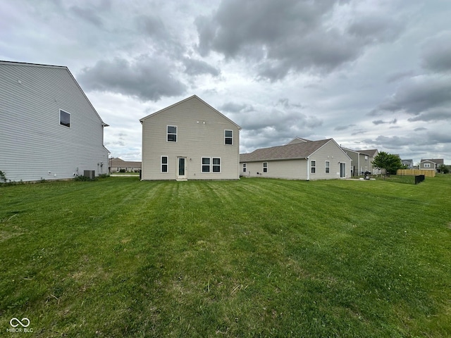 back of house featuring a lawn and central air condition unit