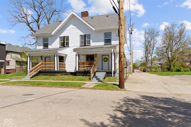 traditional home featuring a shingled roof, covered porch, and a chimney