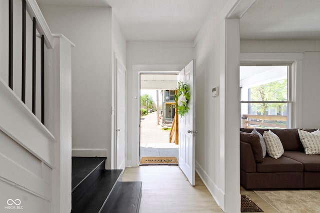 entryway with baseboards and light wood-style flooring