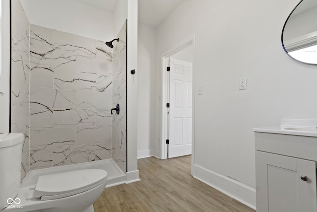 bathroom featuring vanity, a marble finish shower, wood finished floors, and toilet
