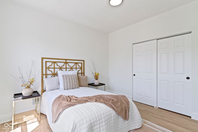 bedroom featuring baseboards, a closet, and wood finished floors