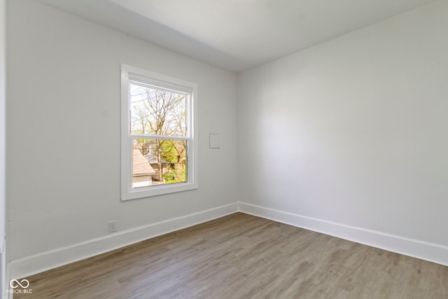 empty room with baseboards and light wood-type flooring