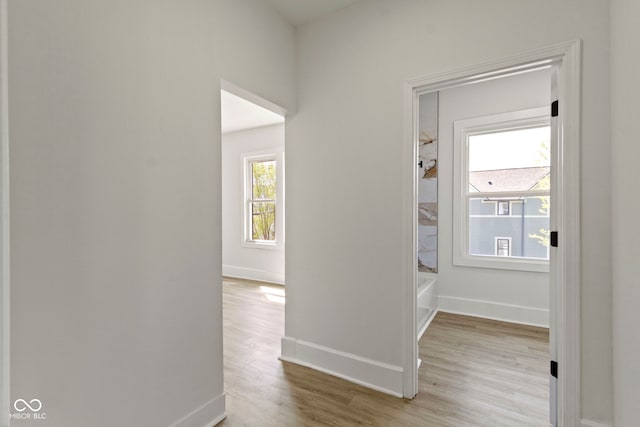 corridor featuring baseboards and wood finished floors