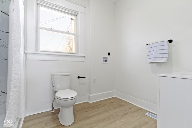 bathroom featuring visible vents, wood finished floors, toilet, baseboards, and a shower with shower curtain