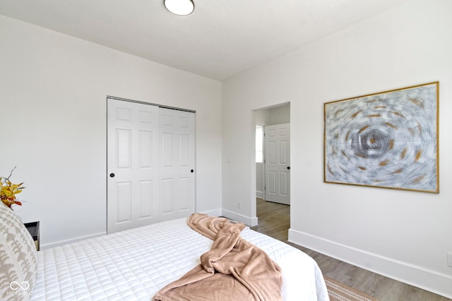 bedroom featuring baseboards, a closet, and wood finished floors