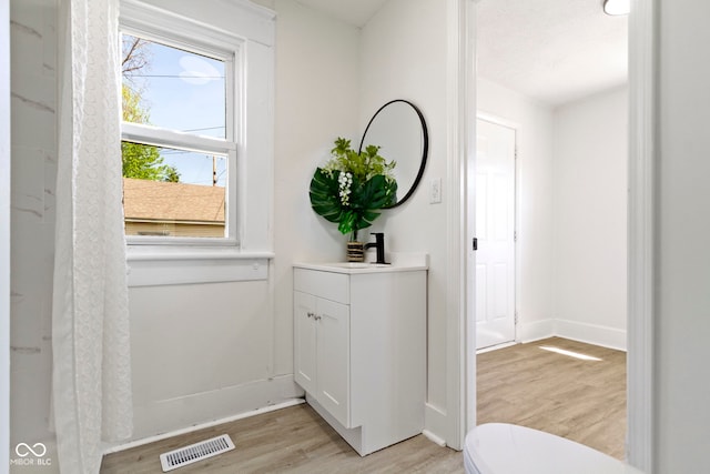 doorway with visible vents, light wood-style flooring, and baseboards