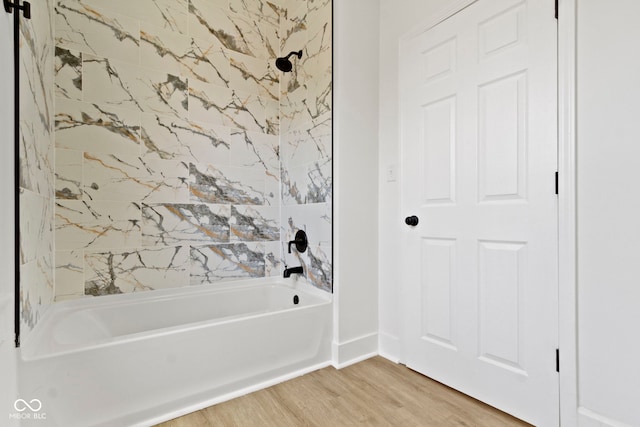 full bathroom featuring baseboards, wood finished floors, and shower / washtub combination