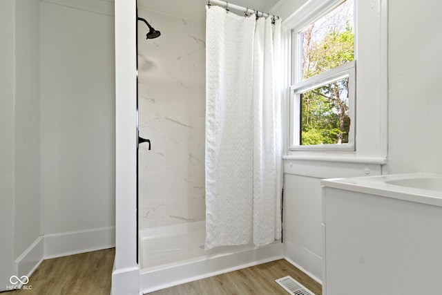 bathroom featuring visible vents, a shower with shower curtain, wood finished floors, and vanity