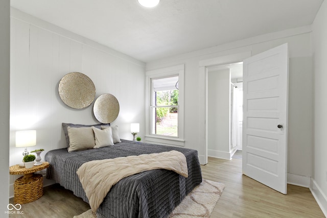 bedroom with baseboards and light wood finished floors
