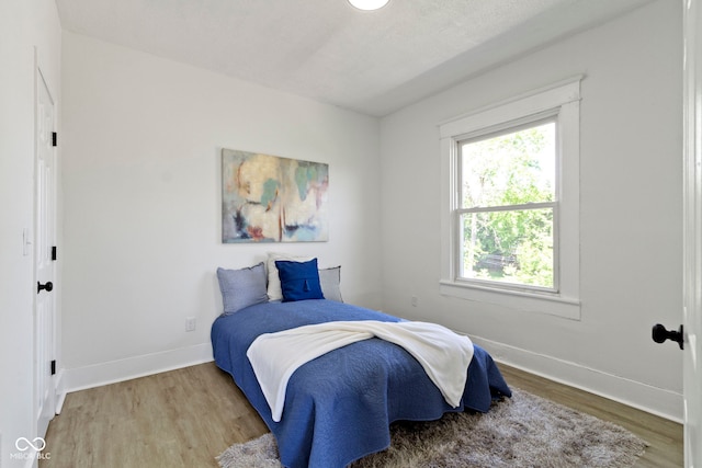 bedroom featuring baseboards and wood finished floors