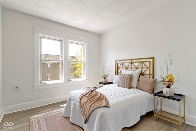 bedroom with baseboards and wood finished floors