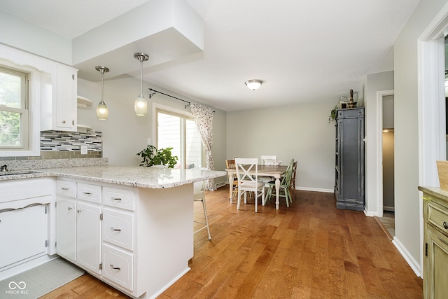 162 Carmelaire Dr, Carmel, IN 46032 - kitchen featuring a peninsula, white cabinets, light wood-type flooring, and backsplash