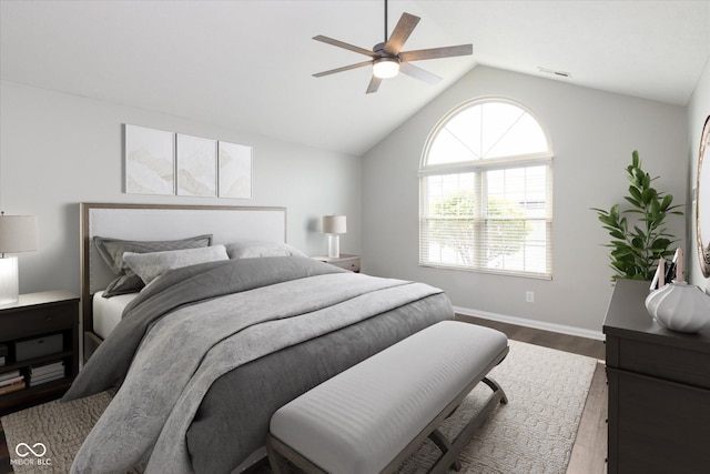 bedroom with wood finished floors, vaulted ceiling, baseboards, and a ceiling fan