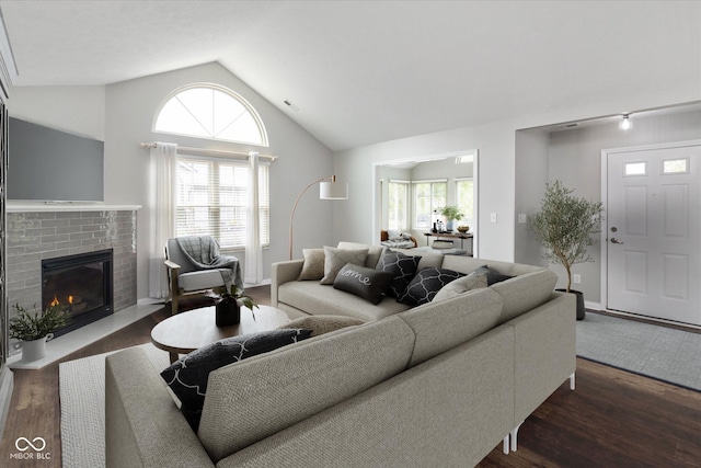 living area with dark wood-style floors, lofted ceiling, and a fireplace