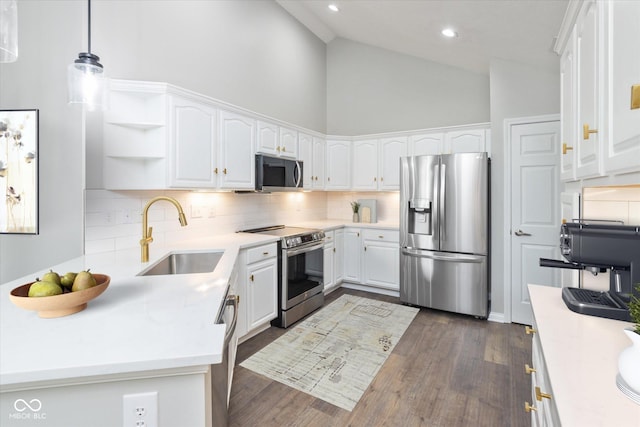 kitchen featuring stainless steel appliances, a sink, high vaulted ceiling, backsplash, and white cabinets
