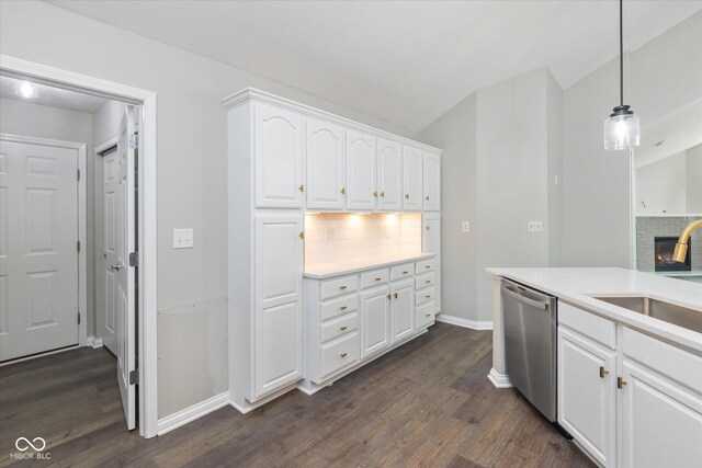 kitchen with dishwasher, a sink, backsplash, dark wood-type flooring, and white cabinetry
