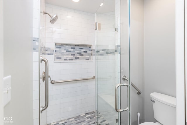 bathroom with toilet and a shower stall