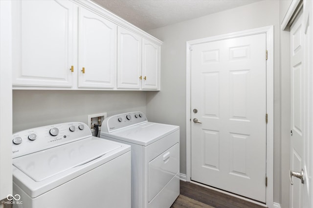 clothes washing area featuring washing machine and clothes dryer, cabinet space, dark wood-style flooring, and a textured ceiling