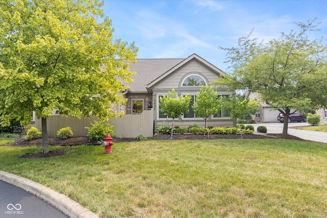 single story home with a front lawn, roof with shingles, and concrete driveway