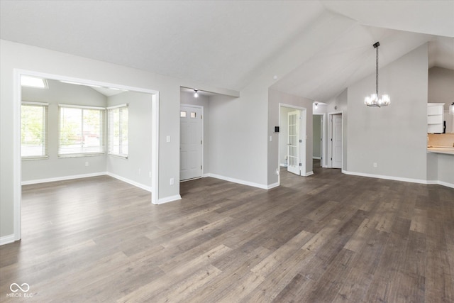 unfurnished living room with a chandelier, dark wood-style flooring, baseboards, and high vaulted ceiling