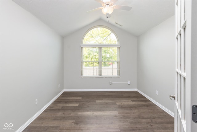 unfurnished room featuring lofted ceiling, a ceiling fan, dark wood-style flooring, and baseboards