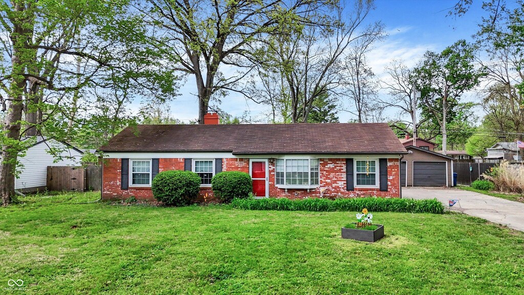 ranch-style house with brick siding, a front lawn, fence, and driveway