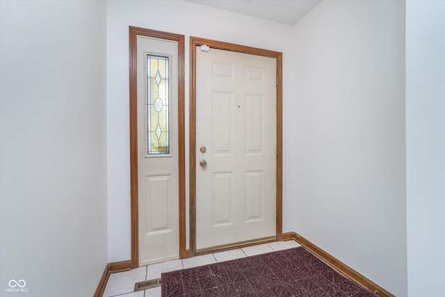 doorway to outside featuring light tile patterned flooring and baseboards
