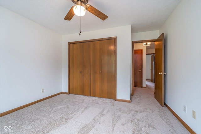 unfurnished bedroom with carpet flooring, a ceiling fan, baseboards, and a closet
